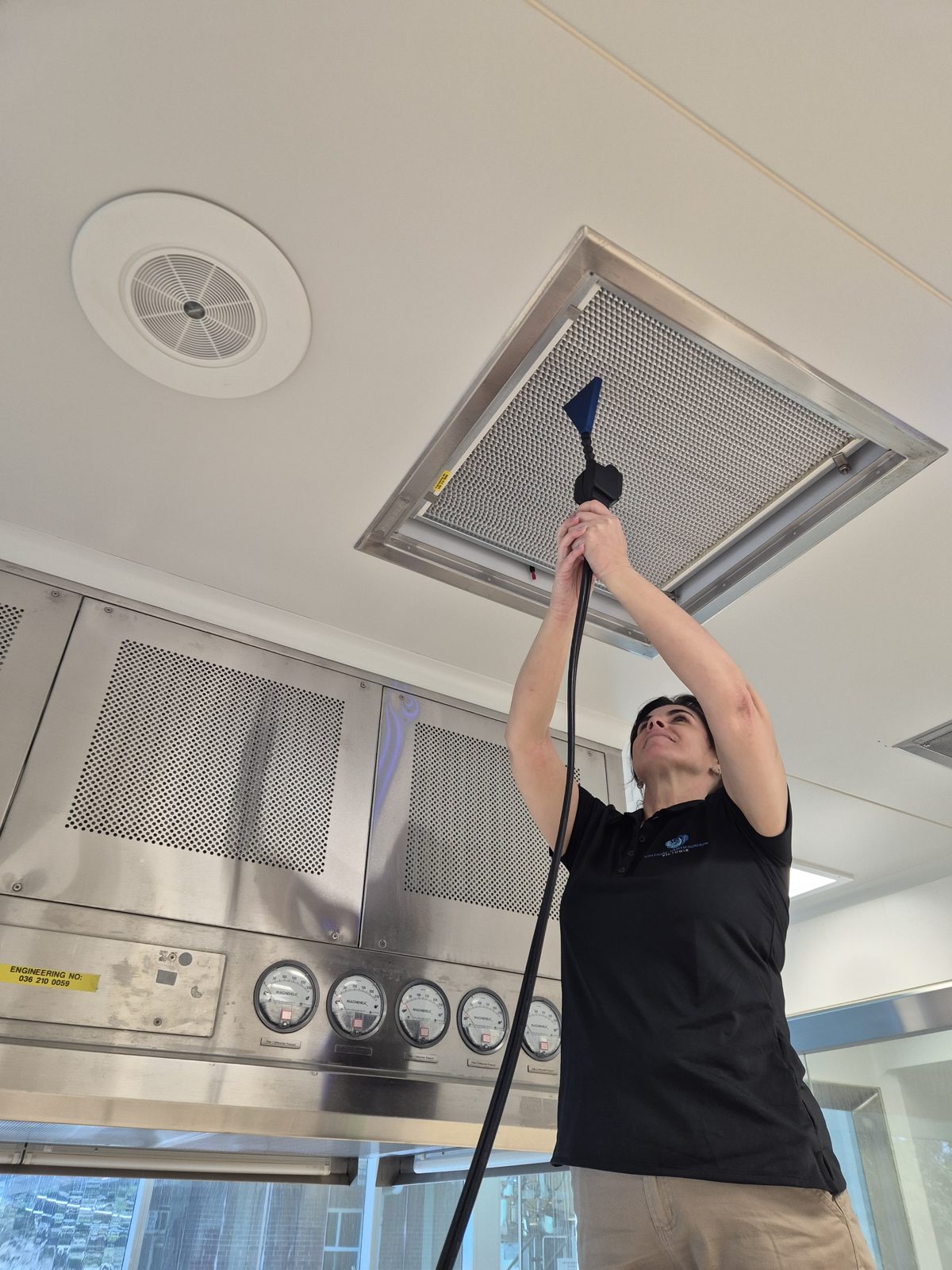 Technician testing a HEPA filter terminal with an airflow probe